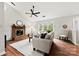 Bright living room with a brick fireplace, hardwood floors, and large windows overlooking the yard at 13324 Kintyre Ct, Matthews, NC 28105