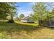 Lush green backyard with mature trees and the home and storage shed situated on the property at 146 37Th Nw St, Hildebran, NC 28601