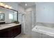 A bright bathroom featuring a soaking tub, walk-in shower, and sleek vanities at 1528 Half Pint Loop, Fort Mill, SC 29708