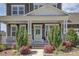 Inviting front porch with a green door, decorative plants, and elegant exterior lighting at 1528 Half Pint Loop, Fort Mill, SC 29708