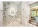 Elegant marble-tiled shower features a built-in seat and grab bar for convenience and safety at 19006 Brandon James Dr, Cornelius, NC 28031