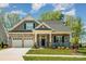 Charming home featuring a stone facade, two-car garage, covered porch, and beautifully landscaped front yard at 19006 Brandon James Dr, Cornelius, NC 28031
