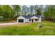 Front exterior showcasing a modern farmhouse design with white siding, black accents, and a well-kept lawn at 2045 Cordia Cir, Newton, NC 28658
