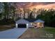 Inviting single-story house features a sleek black garage door and covered front porch, enhancing curb appeal at 2045 Cordia Cir, Newton, NC 28658