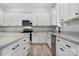 Modern kitchen featuring white cabinets, gray countertops, stainless steel appliances, and luxury vinyl plank flooring at 2045 Cordia Cir, Newton, NC 28658