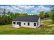 Rear view of this lovely modern farmhouse with a black roof, white siding, and minimalist black window frames at 2045 Cordia Cir, Newton, NC 28658