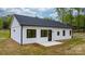 Rear view of this lovely modern farmhouse with a black roof, white siding, and minimalist black window frames at 2045 Cordia Cir, Newton, NC 28658