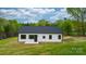 Rear view of this lovely modern farmhouse with a black roof, white siding, and minimalist black window frames at 2045 Cordia Cir, Newton, NC 28658