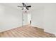 Clean, simple bedroom with light wood floors and a ceiling fan; view to another room at 300 Cherry St, Belmont, NC 28012