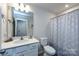Bright bathroom featuring a sink and vanity, toilet, and shower with patterned curtain at 3100 Cheyney Park Dr, Charlotte, NC 28269