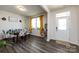 Bright dining room featuring stylish chairs, wood-look floors, modern decor, and natural light from the window at 3100 Cheyney Park Dr, Charlotte, NC 28269