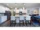 Bright kitchen boasts stainless steel appliances, white cabinets, and a spacious quartz island with pendant lighting at 3100 Cheyney Park Dr, Charlotte, NC 28269