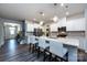 Modern kitchen with white cabinets, stainless steel appliances, large island with seating and wood look floors at 3100 Cheyney Park Dr, Charlotte, NC 28269