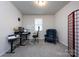 Functional home office with adjustable desk, ergonomic chair, classic blue tufted chair and bright natural light at 3100 Cheyney Park Dr, Charlotte, NC 28269