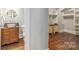 Hallway view of a rustic bathroom with a stone sink and a closet with custom shelving in the home at 3201 Oak Brook Dr, Waxhaw, NC 28173