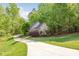 Charming home nestled among trees with a winding driveway and manicured lawn at 3201 Oak Brook Dr, Waxhaw, NC 28173