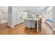 Bright kitchen featuring white cabinetry, a center island, and stylish bar seating on hardwood floors at 3201 Oak Brook Dr, Waxhaw, NC 28173