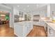 Modern kitchen with white cabinets, a center island, stainless steel appliances, and hardwood floors at 3201 Oak Brook Dr, Waxhaw, NC 28173