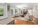 Cozy living room with a stone fireplace, ceiling fan, and lots of natural light with hardwood floors and neutral furniture at 3201 Oak Brook Dr, Waxhaw, NC 28173