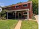 A brick home featuring a covered back patio and outdoor furniture on a well-maintained lawn at 351 Glenwood Dr, Mooresville, NC 28115
