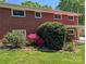 A large backyard showcasing colorful landscaping, a covered patio, and a brick exterior at 351 Glenwood Dr, Mooresville, NC 28115