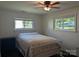 Neutral bedroom with white metal bed, bright natural light from two large windows, and dark floors at 351 Glenwood Dr, Mooresville, NC 28115