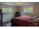 Cozy bedroom with hardwood floors, two bright windows, and neutral colored walls at 351 Glenwood Dr, Mooresville, NC 28115