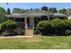 Charming brick home featuring a covered front porch with decorative white columns and landscaped front yard at 351 Glenwood Dr, Mooresville, NC 28115