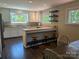 Open kitchen with island seating, granite counters, stainless appliances, and hardwood flooring at 351 Glenwood Dr, Mooresville, NC 28115