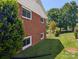 Well-maintained side yard with lush greenery, landscaping, and visible exterior brick wall at 351 Glenwood Dr, Mooresville, NC 28115
