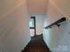 A well-lit stairwell with hardwood steps and white paneled walls leading to a lower level at 351 Glenwood Dr, Mooresville, NC 28115