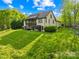 Beautiful home exterior with a spacious green lawn, deck, and lush trees surrounding the property at 401 Yorkfield Dr, Shelby, NC 28150