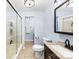 Bathroom featuring a walk-in shower, framed mirror and modern fixtures over granite countertop and a dark wood vanity at 4605 Hedgemore Dr # I, Charlotte, NC 28209