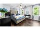 Bedroom featuring tufted headboard, a ceiling fan, and large windows letting in natural light at 4605 Hedgemore Dr # I, Charlotte, NC 28209