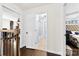 Hallway showing access to a bathroom with glass shower doors, view of bedroom, and dark wooden railing at 4605 Hedgemore Dr # I, Charlotte, NC 28209