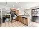 Modern kitchen with stainless steel appliances, wooden cabinets, and view to living area and staircase at 4605 Hedgemore Dr # I, Charlotte, NC 28209