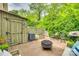 Brick patio features a shed, fire pit, grill, and seating area surrounded by lush greenery at 4607 Hedgemore Dr # H, Charlotte, NC 28209
