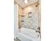 Tiled bathtub with shower and built-in wall niches, creating a functional and stylish bathroom at 4607 Hedgemore Dr # H, Charlotte, NC 28209