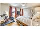 Bedroom with hardwood floors, large windows, TV, and exercise bike, offering comfortable space at 4607 Hedgemore Dr # H, Charlotte, NC 28209