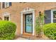 Stylish front door with white trim and wreath detail, complemented by lush green bushes and a lattice trellis at 4607 Hedgemore Dr # H, Charlotte, NC 28209