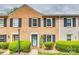 Charming brick townhouse with navy shutters, tidy landscaping and a pop of color from the front door at 4607 Hedgemore Dr # H, Charlotte, NC 28209
