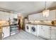 Bright kitchen features white cabinets, stainless steel appliances, granite countertops and laundry area at 4607 Hedgemore Dr # H, Charlotte, NC 28209
