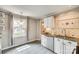 Updated kitchen with white cabinets, stainless steel appliances, granite countertops, and ample natural light at 4607 Hedgemore Dr # H, Charlotte, NC 28209
