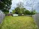 Expansive backyard with lush green grass and storage shed, surrounded by a wooden fence at 4623 Monmouth Dr, Charlotte, NC 28269