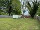Spacious backyard featuring a shed and surrounded by lush greenery and a wooden fence at 4623 Monmouth Dr, Charlotte, NC 28269
