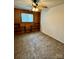 This bedroom features carpet, wood paneled walls, a ceiling fan and built in bookshelves at 4623 Monmouth Dr, Charlotte, NC 28269