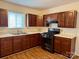 Well-lit kitchen with wood cabinets, laminate counters and stainless steel sink at 4623 Monmouth Dr, Charlotte, NC 28269