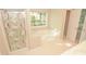 Modern bathroom with glass shower door, garden tub, and window at 4704 Beech Crest Pl, Charlotte, NC 28269