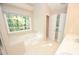Bright bathroom features a garden tub under a window and white vanity with double sinks at 4704 Beech Crest Pl, Charlotte, NC 28269
