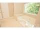 Bright bathroom features a garden tub under a window and an enclosed shower at 4704 Beech Crest Pl, Charlotte, NC 28269